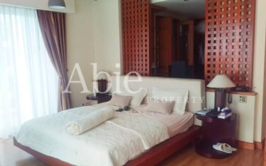 Kamar tidur kosong di unit 2 kamar The Pakubuwono Residence 178m², dengan jendela besar, pencahayaan alami melimpah, dan lantai kayu elegan.