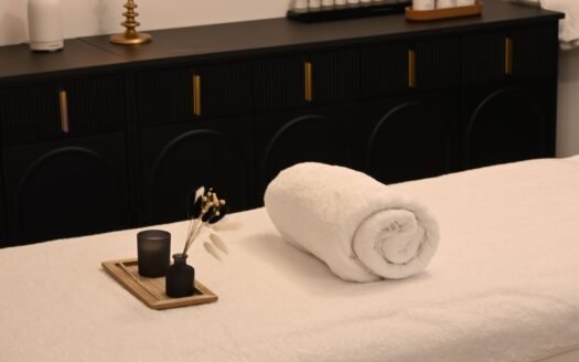 a towel and some fragrance on a bed