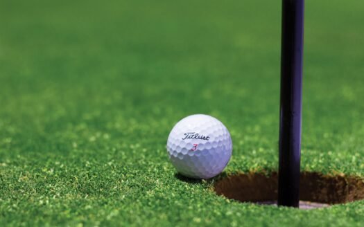 a golf ball near hole in a green golf course