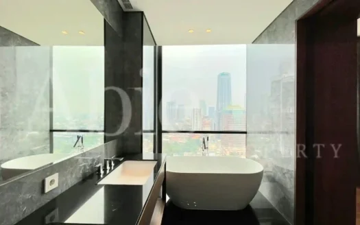 Kamar mandi mewah dengan bathtub menghadap jendela besar dan pemandangan kota di Regent Residence Jakarta