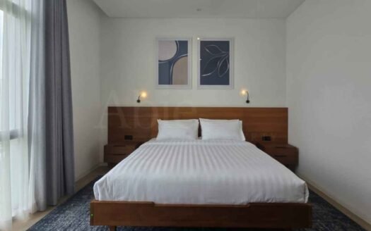 Kamar tidur dilihat dari depan dengan desain minimalis dan ranjang kayu di verde two