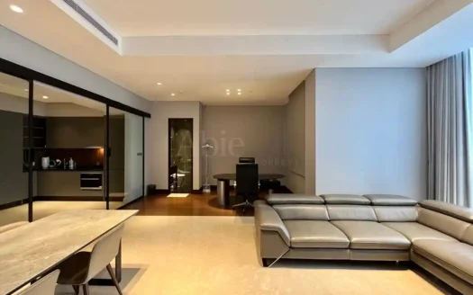 Ruang keluarga luas dengan sofa kulit dan pencahayaan alami di Apartemen Regent Residence Jakarta