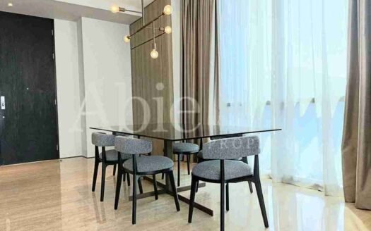 Ruang makan modern dengan meja dan kursi di apartemen Lavie All Suites.