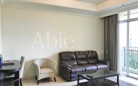 Ruang tamu luas dan nyaman di Apartemen The Pakubuwono View, dengan desain modern dan pencahayaan alami.